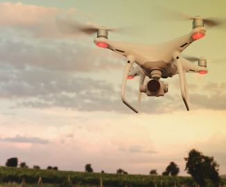 white drone hovering over field