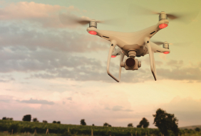 white drone hovering over field